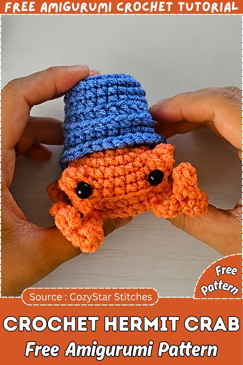 Promotional graphic showing hands holding a completed orange crochet hermit crab amigurumi with a blue bucket shell and black safety eyes.