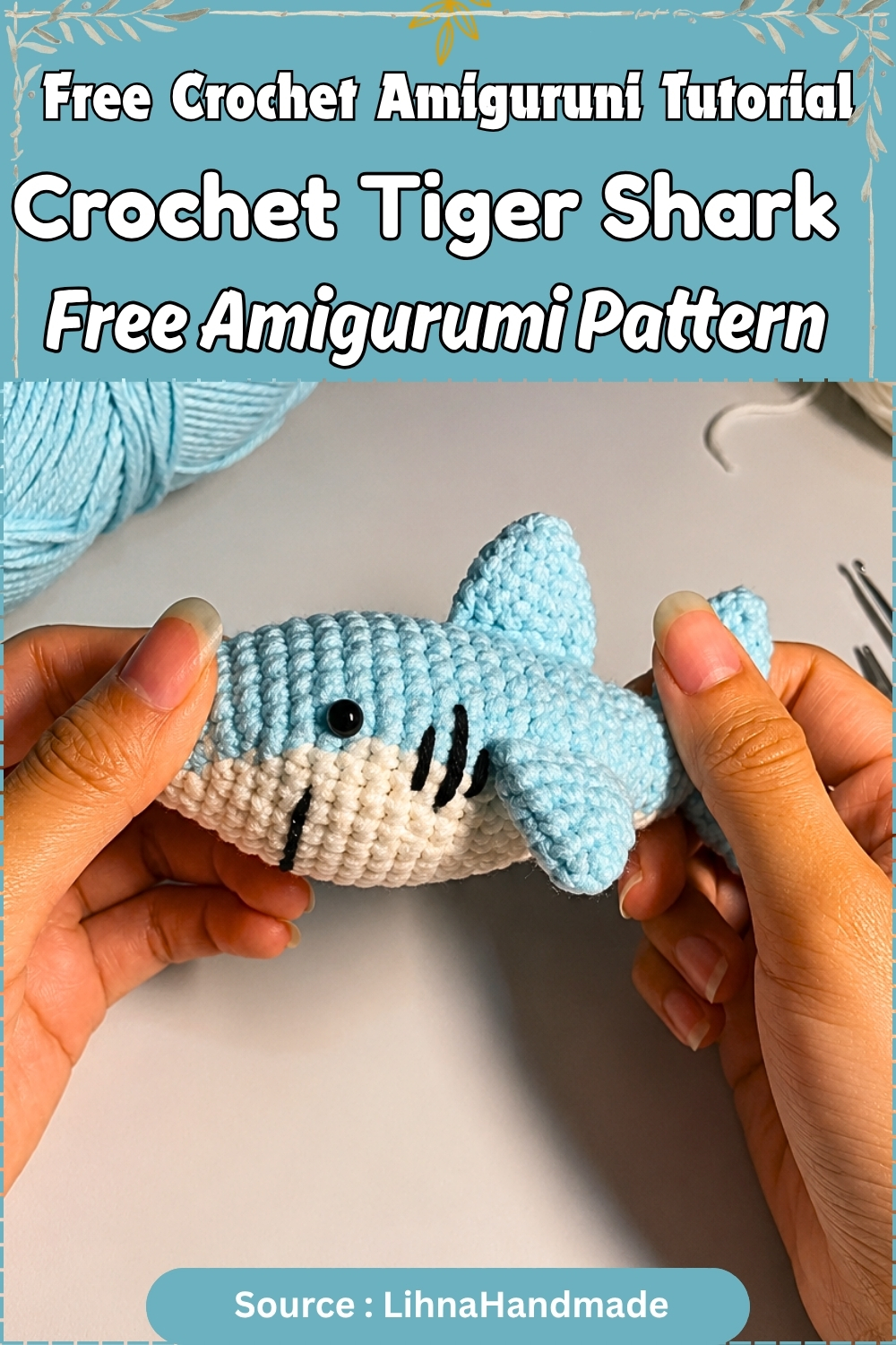 Promotional graphic showing hands holding a completed light blue crochet tiger shark amigurumi with cream belly and embroidered gills against a neutral background.