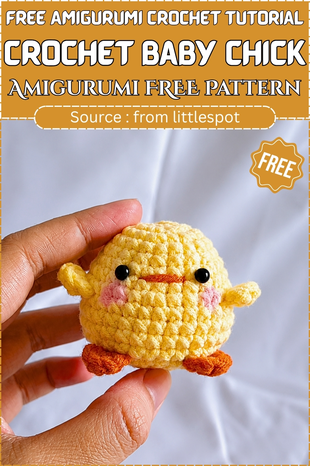 A finished yellow crochet baby chick amigurumi with orange feet and wings held up for a free pattern.