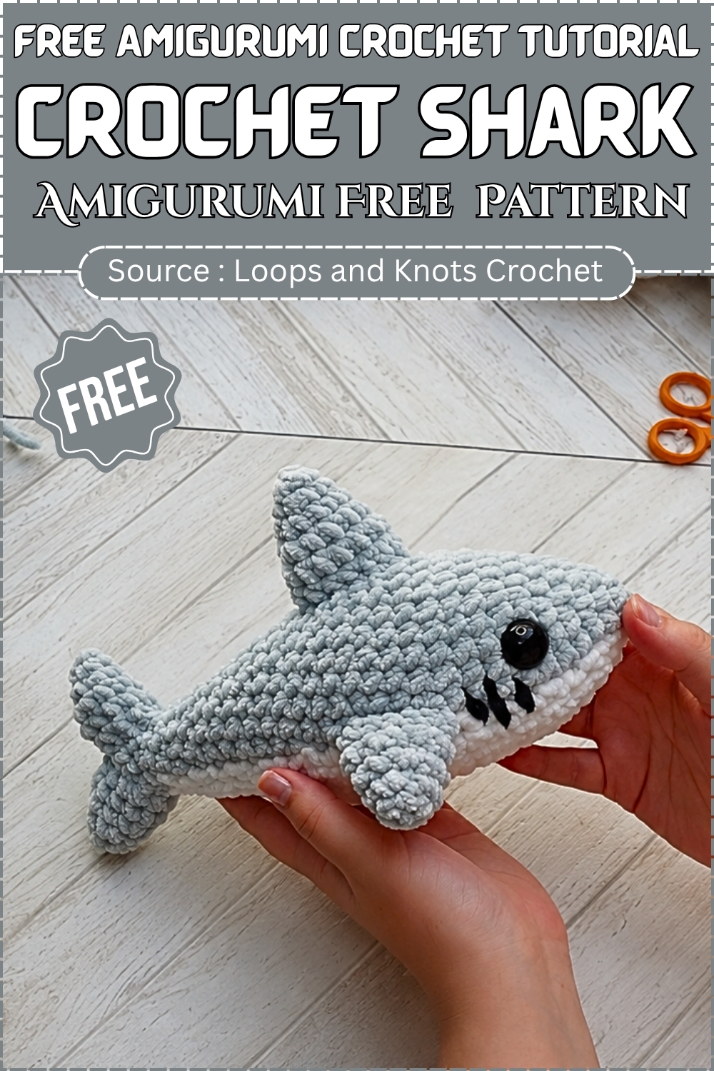 Promotional graphic showing hands holding a finished gray chenille crochet shark amigurumi with white belly and embroidered teeth on a wooden floor background.