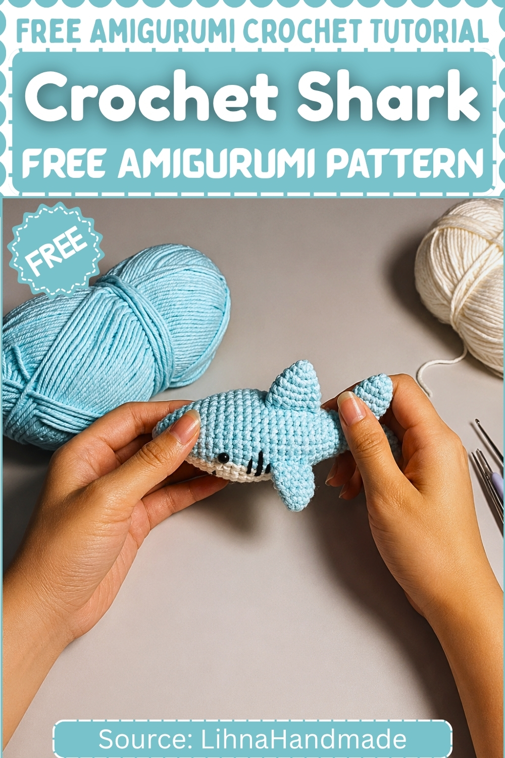 A finished light blue crochet shark amigurumi held in two hands above a gray surface, with blue and white yarn and crochet hooks arranged around it on a branded free pattern graphic.
