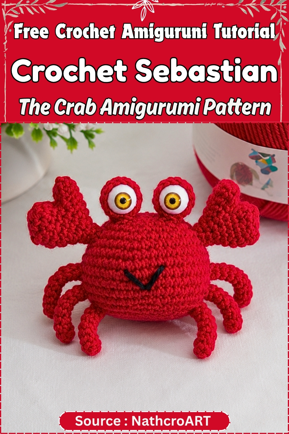 Completed red crochet Sebastian the crab amigurumi with large yellow eyes, raised claws, and six legs displayed on a white surface with green foliage in the background.